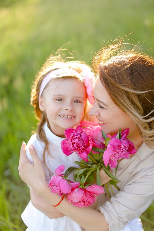 Portrait d'une jolie mère assise avec une petite fille sur l'herbe. images libres de droits