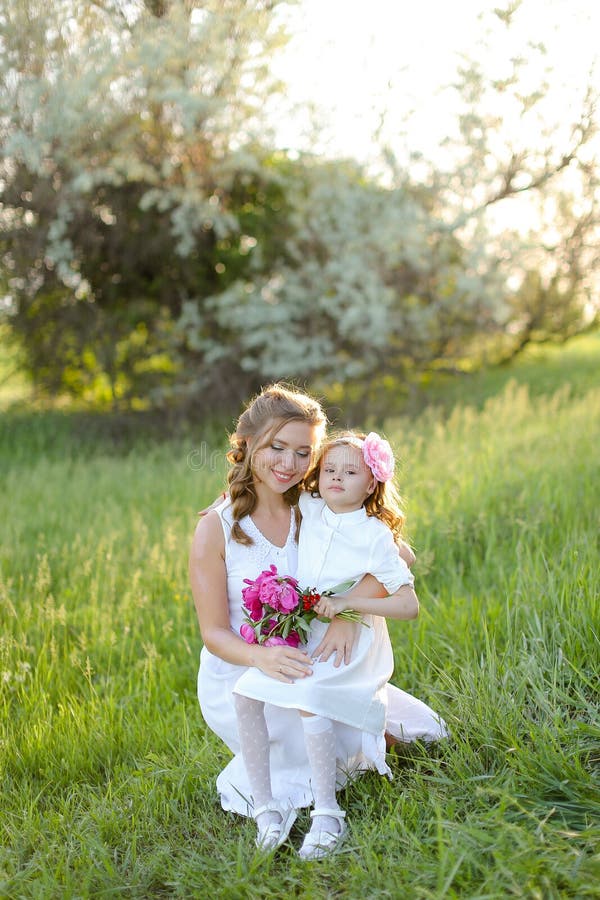 Portrait d'une jolie mère caucasienne assise avec une petite fille sur l'herbe. photo libre de droits