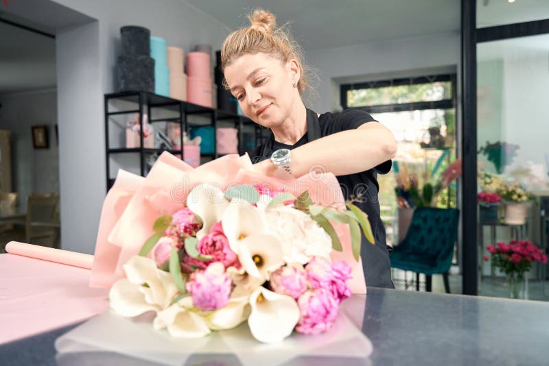 Portrait d'une mignonne fleuriste à l'oeuvre dans un fleuriste image stock