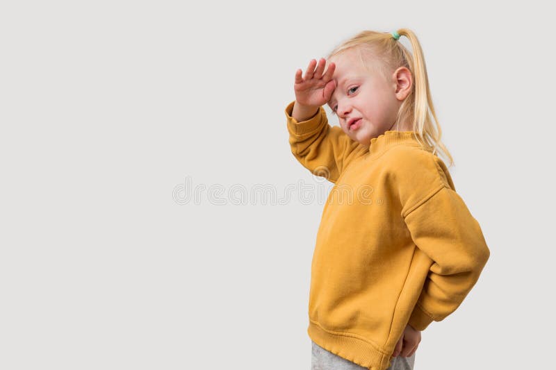Portrait d'une petite fille aux cheveux blonds dans un capot jaune sur fond blanc photos stock