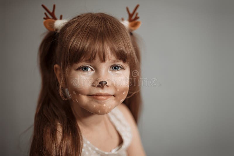 Portrait D'une Petite Fille En Bas âge Avec Un Bandeau Sur La Tête Sous  Forme De Cornes De Cerfs Et Un Jouet De Noël Dans Les Main Photo stock -  Image du