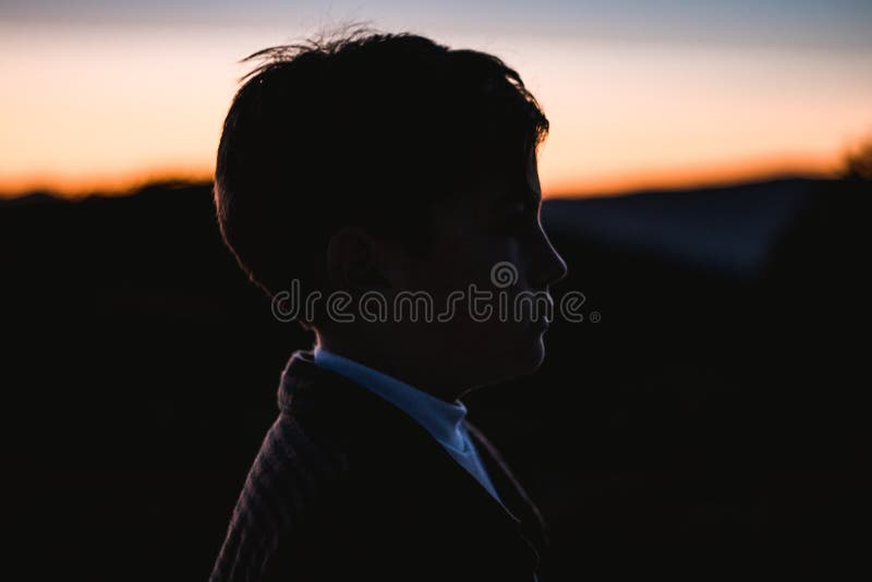 Portrait d'une silhouette d'un petit garçon dans un coucher du soleil dans la campagne Enfant en nature image stock Portrait d'une silhouette d'un petit garçon dans un coucher du soleil dans la campagne Enfant en nature image stock