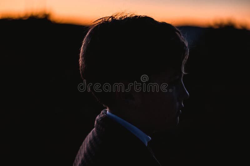 Portrait d'une silhouette d'un petit garçon dans un coucher du soleil dans la campagne Enfant en nature photos stock Portrait d'une silhouette d'un petit garçon dans un coucher du soleil dans la campagne Enfant en nature photos stock