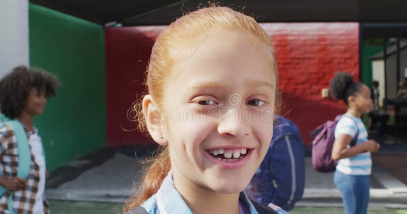 Portrait d'une écolière caucasienne heureuse avec un groupe diversifié d'enfants heureux en arrière-plan clips vidéos