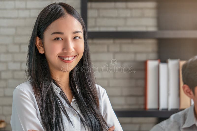 Portrait d'étudiante asiatique avec l'étagère dans la bibliothèque photo libre de droits