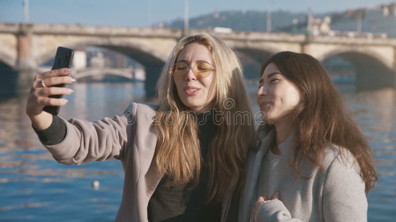 Portrait de beaux amis souriant au téléphone. jeunes femmes faisant selfie sur smartphone. amis positifs marche banque de vidéos