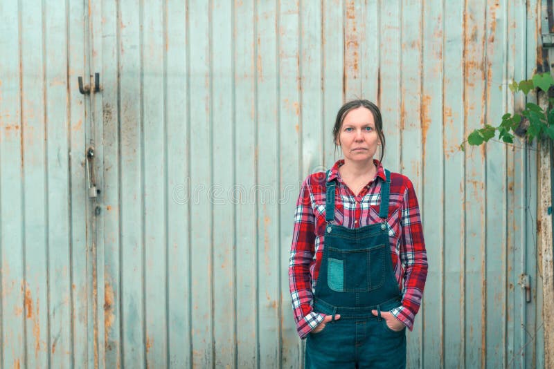 Portrait de bel agriculteur féminin devant le hangar de ferme photos libres de droits Portrait de bel agriculteur féminin devant le hangar de ferme photos libres de droits