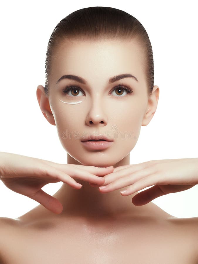 Portrait de belle femme appliquant de la crème à son visage pour des soins de la peau photos stock Portrait de belle femme appliquant de la crème à son visage pour des soins de la peau photos stock