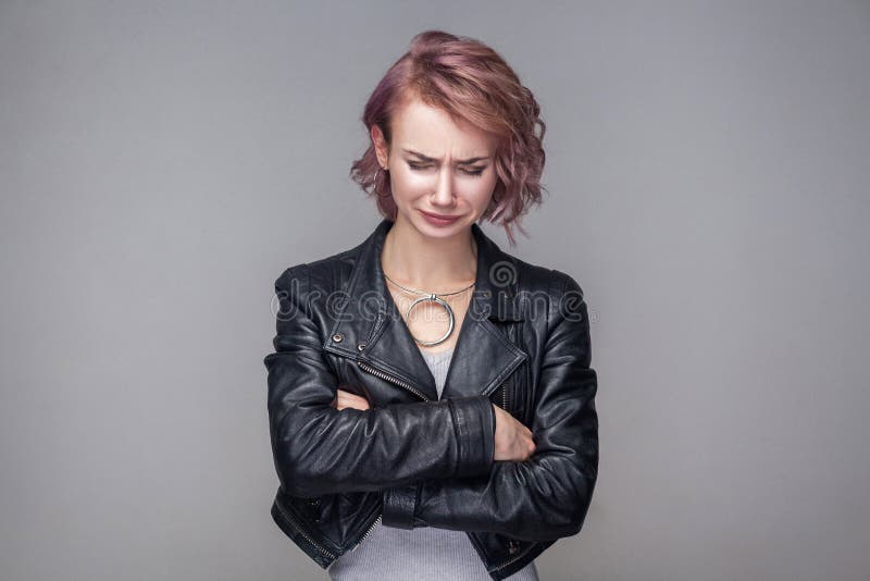 Portrait de belle fille déprimée avec la coiffure et le maquillage courts dans la position noire de veste en cuir de style occasi photo stock Portrait de belle fille déprimée avec la coiffure et le maquillage courts dans la position noire de veste en cuir de style occasi photo stock