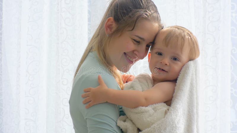 Portrait de belle jeune femme caressant et embrassant son fils de bébé