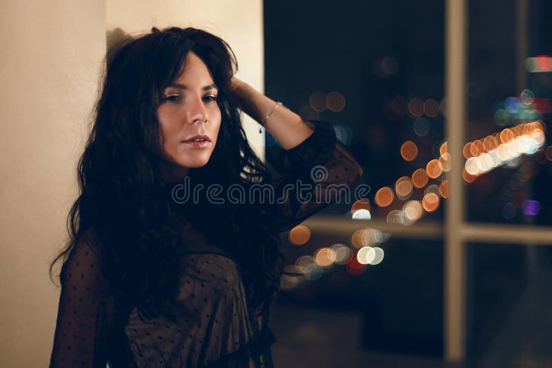 Portrait de belle jeune femme dans la robe de cocktail noire se penchant sur le mur photos stock Portrait de belle jeune femme dans la robe de cocktail noire se penchant sur le mur photos stock