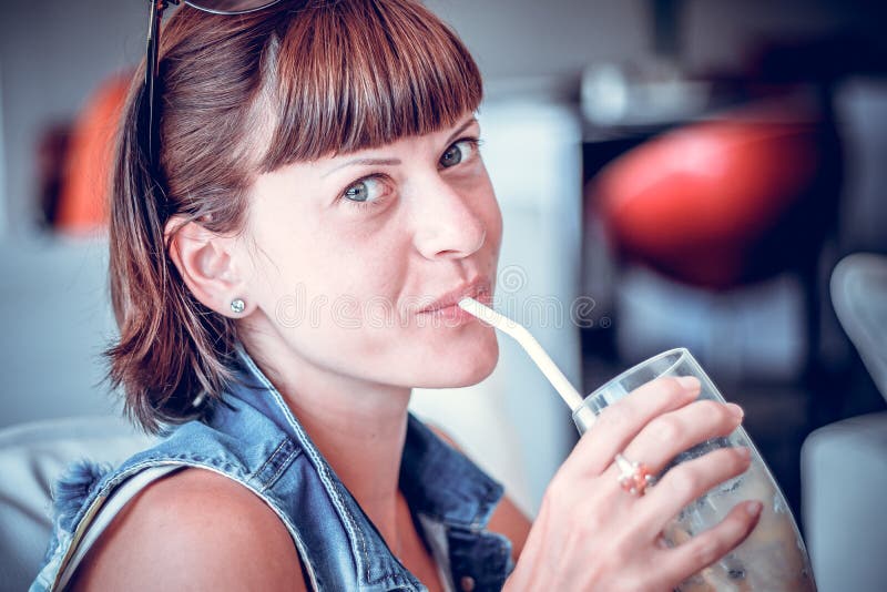 Portrait de belle jeune femme en cocktail potable de café Cocktail régénérateur délicieux le jour ensoleillé Boissons de fruit
