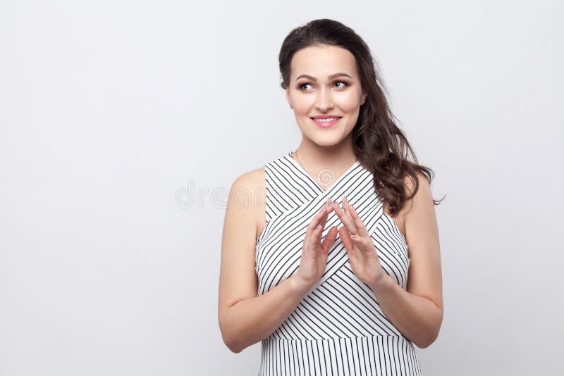 Portrait de belle jeune femme souriante toothy de brune avec le maquillage et la position rayée de robe et regarder loin avec le photo libre de droits Portrait de belle jeune femme souriante toothy de brune avec le maquillage et la position rayée de robe et regarder loin avec le photo libre de droits