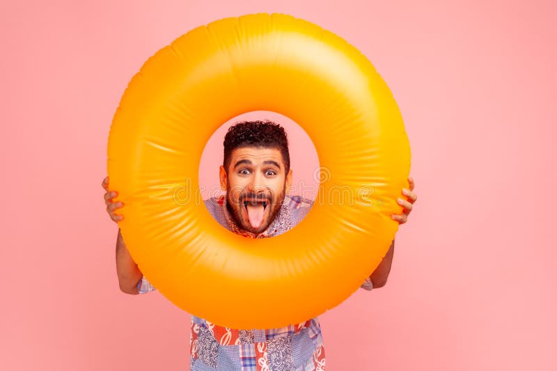 Portrait de brune barbu fou excité homme tenant un anneau de caoutchouc orange dans les mains regarder la caméra avec une expressi photo stock