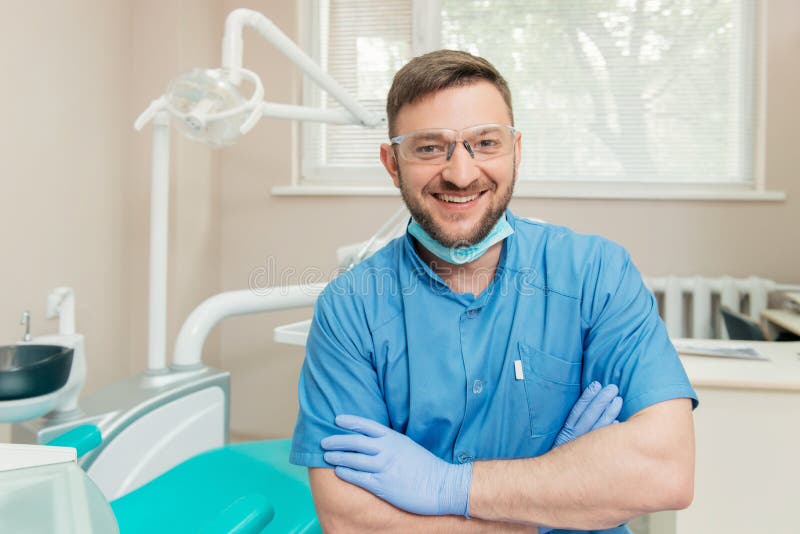 Portrait of friendly dentist in the dental office with folded hands. Portrait of friendly dentist in the dental office with folded hands