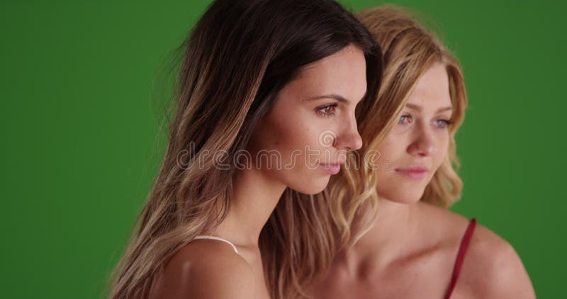 Portrait de deux belles femmes posant sur écran vert banque de vidéos