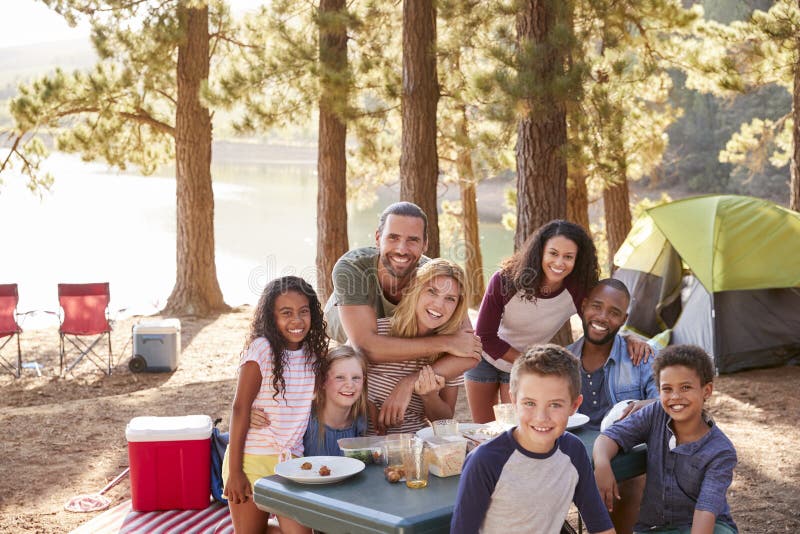 Portrait de famille avec des amis campant par le lac dans la forêt photo stock Portrait de famille avec des amis campant par le lac dans la forêt photo stock