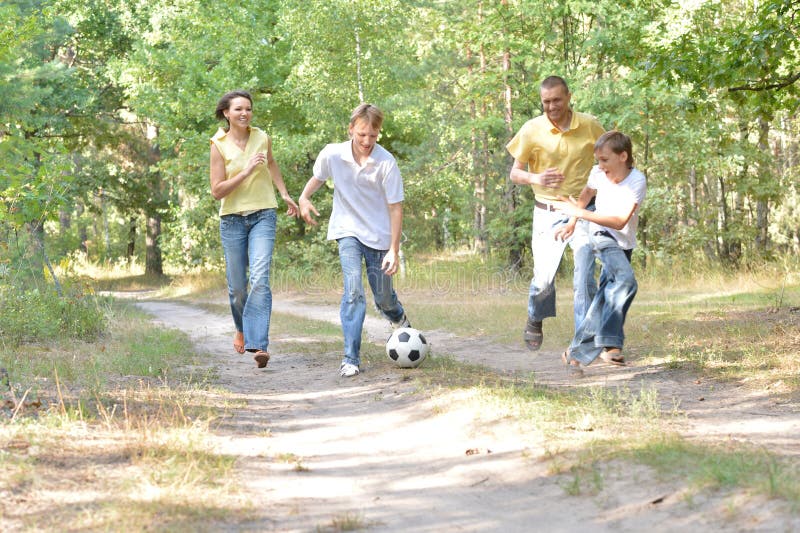 Portrait de famille heureuse jouant au football en parc photos libres de droits Portrait de famille heureuse jouant au football en parc photos libres de droits