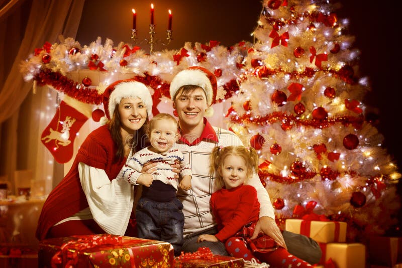 Portrait de famille de Noël dans les lumières intérieures d'arbre de Noël, nouvelle année photographie stock libre de droits Portrait de famille de Noël dans les lumières intérieures d'arbre de Noël, nouvelle année photographie stock libre de droits