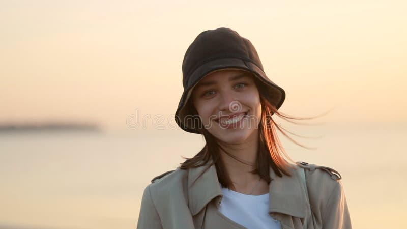 Portrait de femme face à la caméra et debout sur la plage de mer pour égaliser le coucher du soleil. banque de vidéos