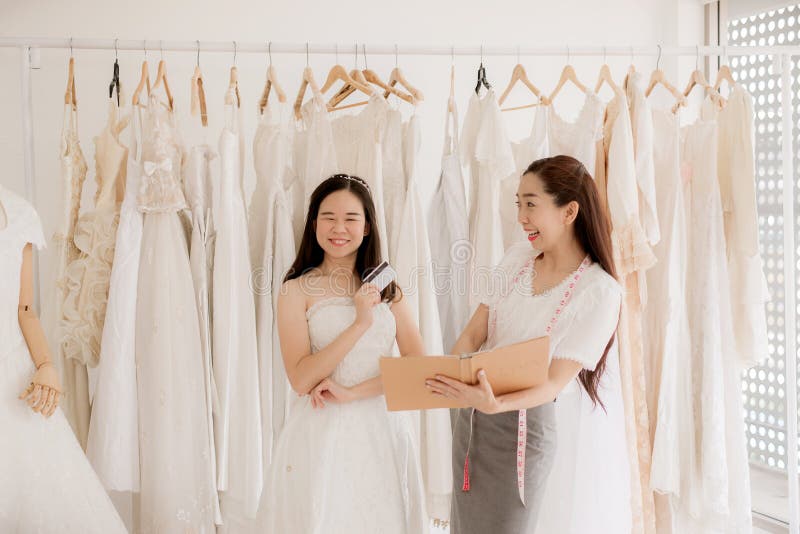 Portrait de femme heureuse tenant la carte de cr?dit dans le propri?taire de magasin de robe de mariage, la belle couturi?re r?us photographie stock Portrait de femme heureuse tenant la carte de cr?dit dans le propri?taire de magasin de robe de mariage, la belle couturi?re r?us photographie stock