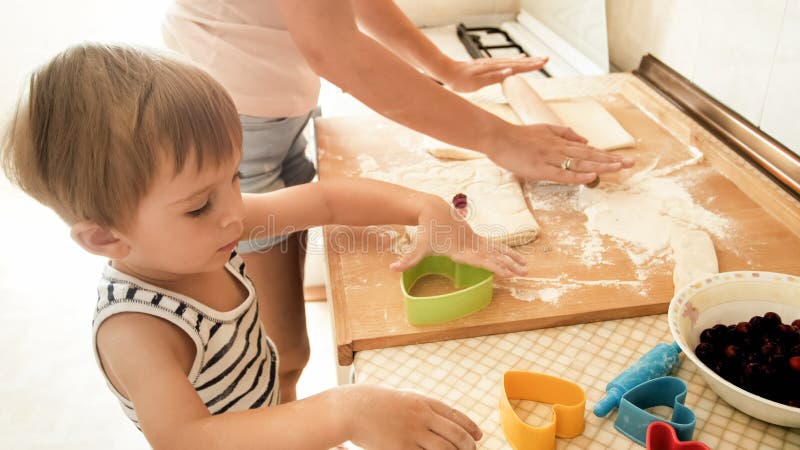 Portrait de gar?on de sourire heureux d'enfant en bas ?ge avec la jeune cuisson de m?re et de la cuisson sur la cuisine Enseignem photo stock Portrait de gar?on de sourire heureux d'enfant en bas ?ge avec la jeune cuisson de m?re et de la cuisson sur la cuisine Enseignem photo stock