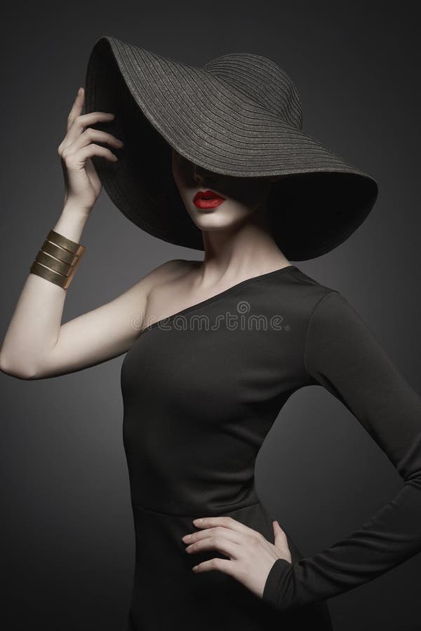 Portrait de jeune dame avec le chapeau noir et la robe de soirée