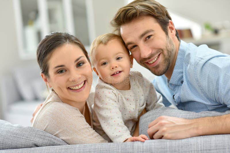 Portrait de jeune famille heureuse sur le sourire de sofa image stock