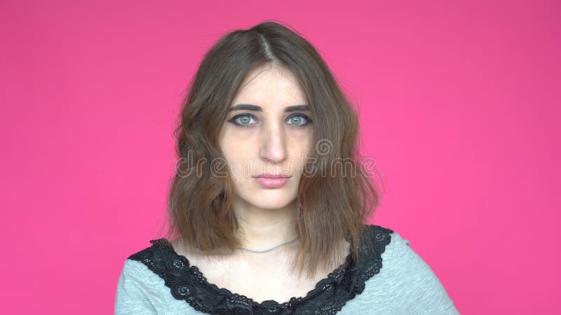 Portrait de jeune femme avec les yeux verts regardant l'appareil-photo sur le ` rose de fond clips vidéos