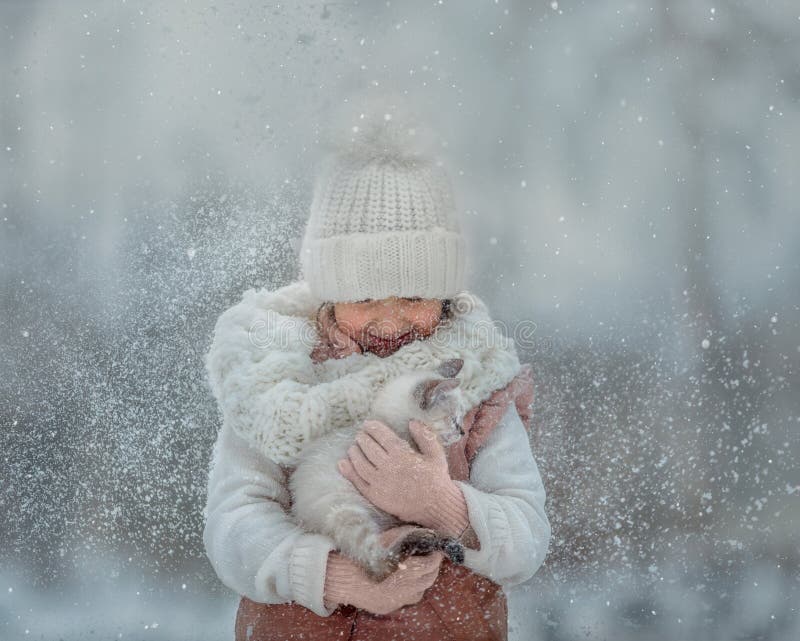 Young girl portrait with tibet kitten under snow in winter park. Young girl portrait with tibet kitten under snow in winter park