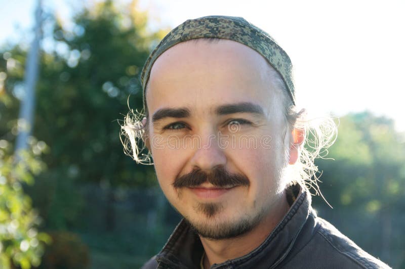 Portrait de jeune homme avec la barbe, les earlocks, les sidelocks et la moustache au jour ensoleillé dehors Personne de sourire image libre de droits Portrait de jeune homme avec la barbe, les earlocks, les sidelocks et la moustache au jour ensoleillé dehors Personne de sourire image libre de droits