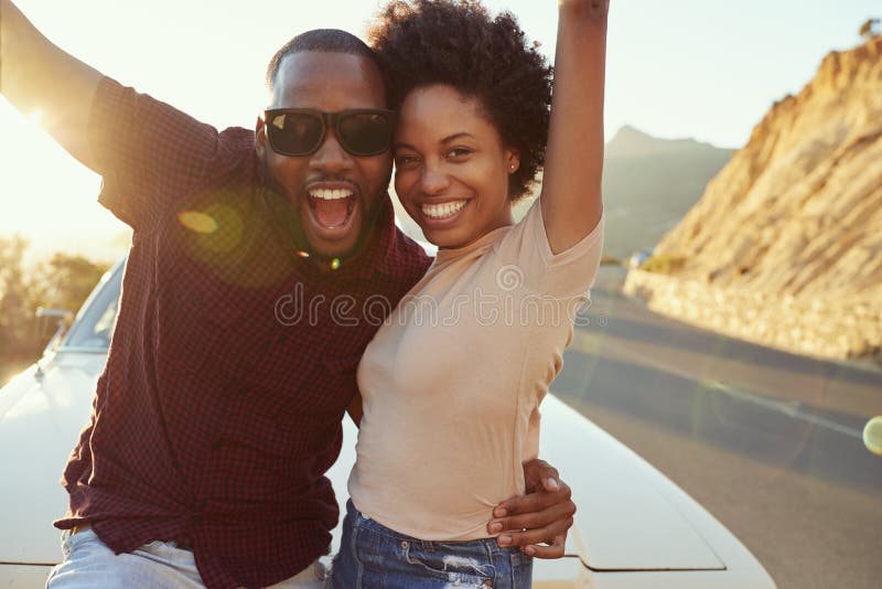 Portrait de jeunes couples se tenant à côté de la voiture classique photographie stock libre de droits Portrait de jeunes couples se tenant à côté de la voiture classique photographie stock libre de droits