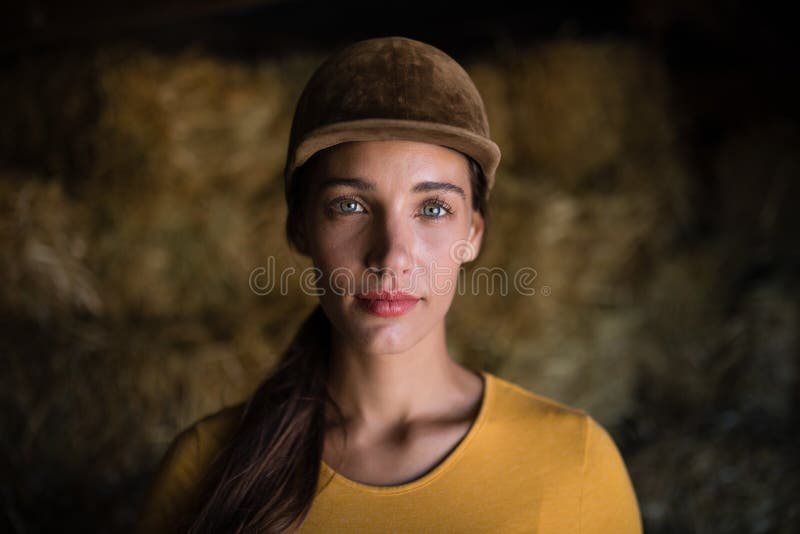 Portrait de jockey féminin sérieux dans l'écurie images libres de droits Portrait de jockey féminin sérieux dans l'écurie images libres de droits