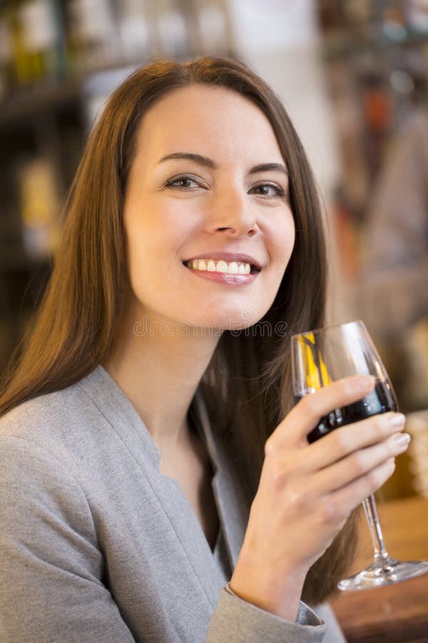 Portrait de jolie jeune femme buvant du vin rouge dans le restaurant photographie stock libre de droits Portrait de jolie jeune femme buvant du vin rouge dans le restaurant photographie stock libre de droits