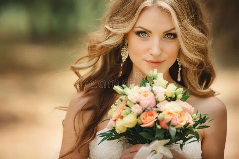 Portrait de jolie mariée de luxe avec le bouquet de roses hors mariage. La jeune femme avec le professionnel composent et coiffure image libre de droits