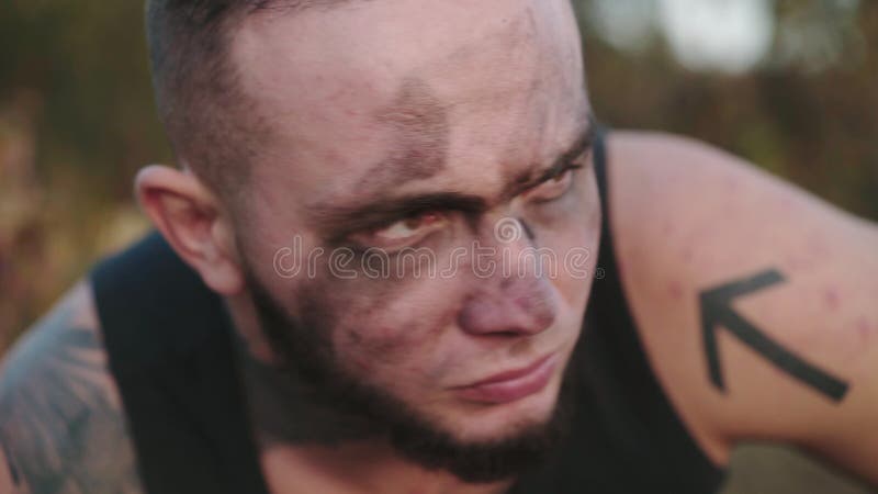 Portrait de l'athlète brutal avec la suie sur le visage regarder dans la caméra sur la nature clips vidéos