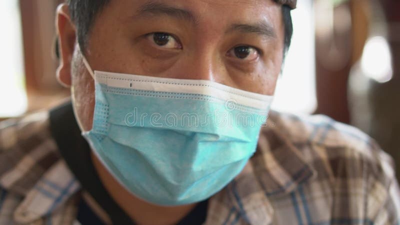 Portrait de l'homme d'âge moyen dans un masque médical et en regardant la caméra coronavirus covid19 et la pollution de l'air banque de vidéos