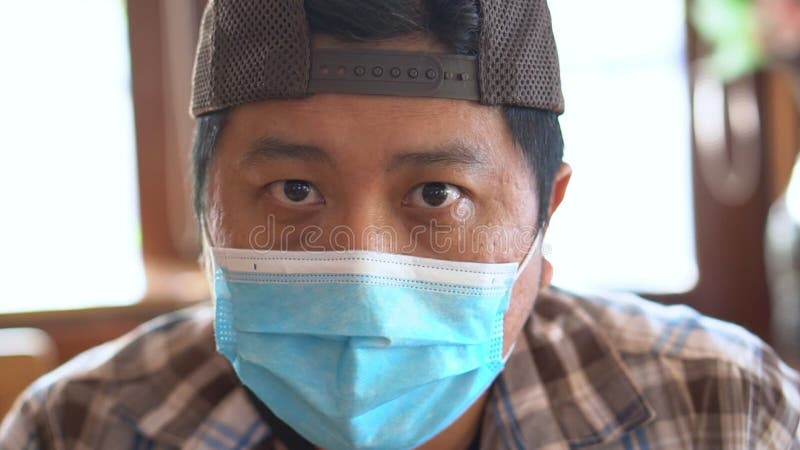 Portrait de l'homme d'âge moyen dans un masque médical et en regardant la caméra coronavirus covid19 et la pollution de l'air banque de vidéos