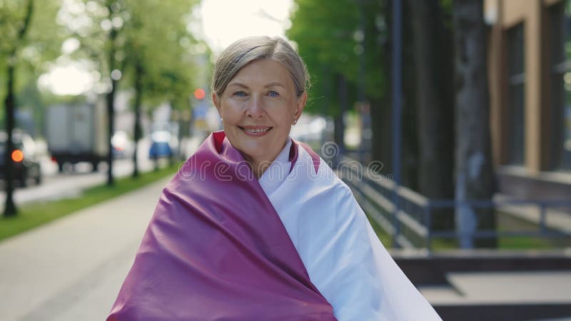 Portrait de la femme mature portant le drapeau du qatar sur fond de rue. les gens votent les fonds du football patriotique