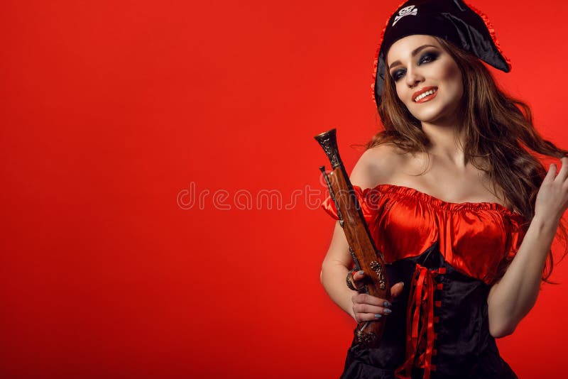 Portrait de la femme sexy magnifique avec le maquillage provocateur mordant sa lèvre et tenant l'arme à feu en bois de vintage image stock Portrait de la femme sexy magnifique avec le maquillage provocateur mordant sa lèvre et tenant l'arme à feu en bois de vintage image stock