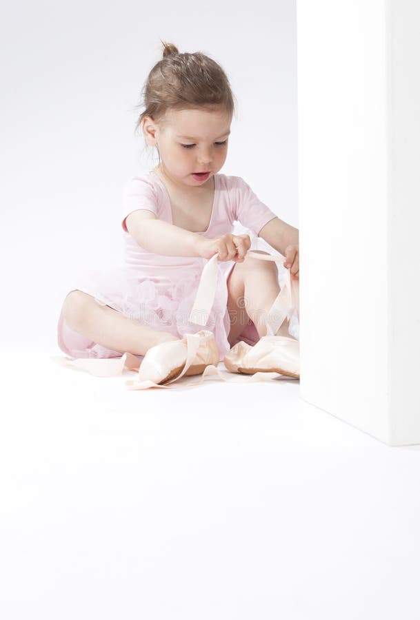 Portrait de la fille caucasienne concentrée mignonne essayant sur Pointes miniature image libre de droits Portrait de la fille caucasienne concentrée mignonne essayant sur Pointes miniature image libre de droits
