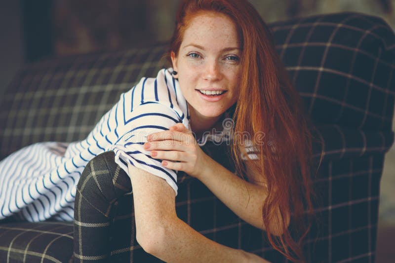 Portrait de la jeune belle femme rousse détendant à la maison le soir confortable d'hiver d'ot d'automne photos libres de droits Portrait de la jeune belle femme rousse détendant à la maison le soir confortable d'hiver d'ot d'automne photos libres de droits