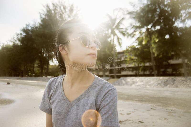 Portrait de la jeune femme asiatique s'asseyant à la plage Concept de temps de vacances Fond brouillé Moment de coucher du soleil photo libre de droits Portrait de la jeune femme asiatique s'asseyant à la plage Concept de temps de vacances Fond brouillé Moment de coucher du soleil photo libre de droits