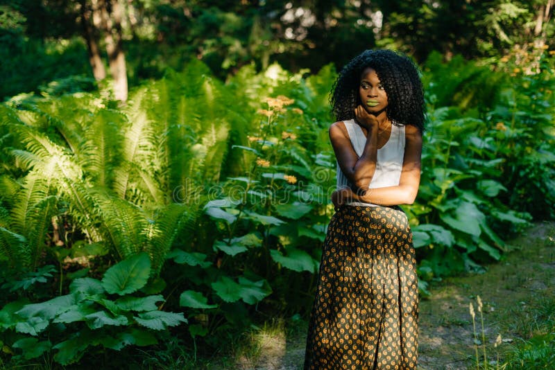 La Jeune Fille Africaine Attirante Avec Le Maquillage Naturel Lit Le Livre Pendant Le Pique