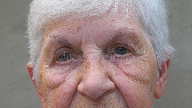 Portrait de la vieille grand-mère avec un triste regard. visage ridé d'une vieille dame regardant dans la caméra. douleur faciale clips vidéos