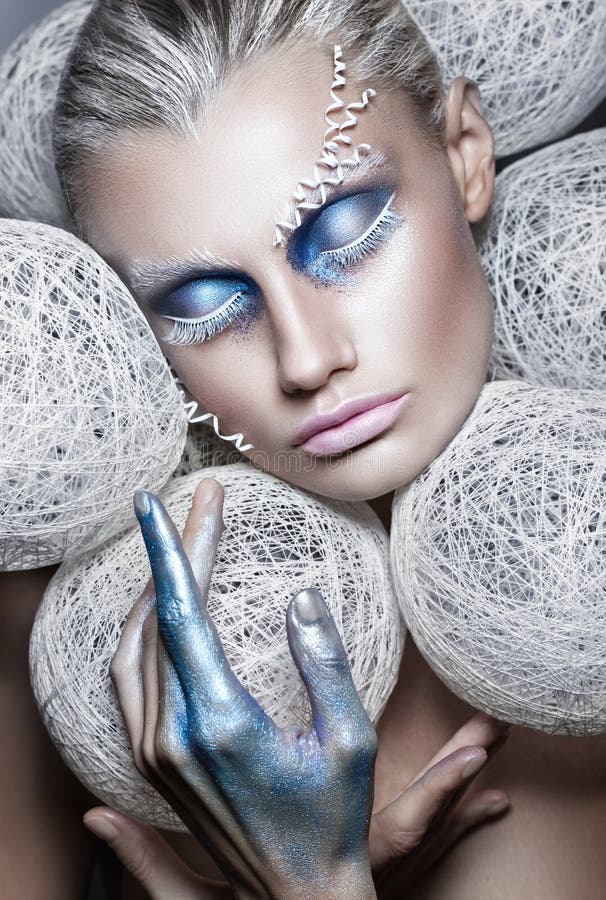 Portrait de mode de beauté de belle femme avec les boules blanches de maquillage créatif autour du modèle principal restauration images stock Portrait de mode de beauté de belle femme avec les boules blanches de maquillage créatif autour du modèle principal restauration images stock