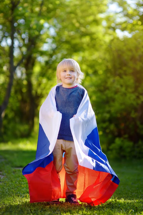 Portrait de petit garçon mignon en parc public d'été avec le drapeau russe sur le fond Enfant de fans soutenant et encourageant l photo stock Portrait de petit garçon mignon en parc public d'été avec le drapeau russe sur le fond Enfant de fans soutenant et encourageant l photo stock