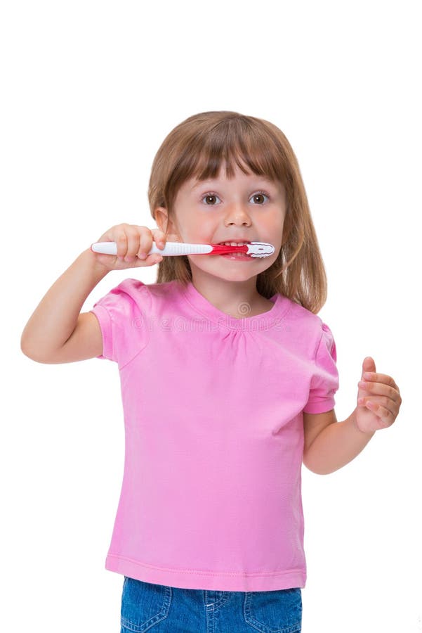 Portrait de petite fille mignonne 3 ans dans le T-shirt rose se brossant les dents d'isolement sur le fond blanc photographie stock Portrait de petite fille mignonne 3 ans dans le T-shirt rose se brossant les dents d'isolement sur le fond blanc photographie stock