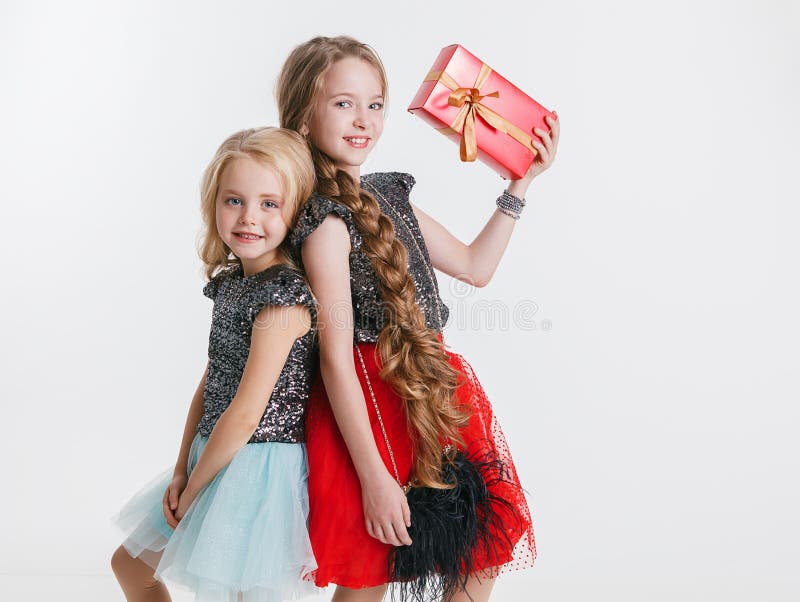 Portrait de petites filles avec la coiffure bouclée se tenant sur la fête de vacances dans la robe avec des paillettes, tenant le photos stock Portrait de petites filles avec la coiffure bouclée se tenant sur la fête de vacances dans la robe avec des paillettes, tenant le photos stock