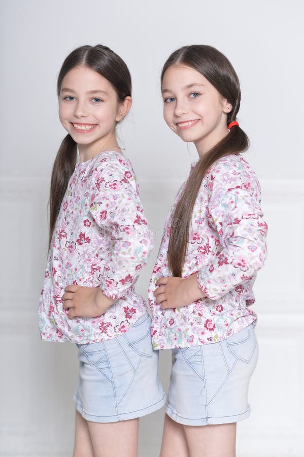 Portrait de petites filles mignonnes posant sur le fond blanc image libre de droits Portrait de petites filles mignonnes posant sur le fond blanc image libre de droits